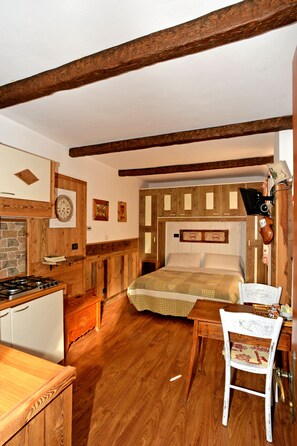 A rustic room with a bed, wooden furniture, a stone wall, and a clock on the wall. - B&B Il Torchio (Saint-Vincent)