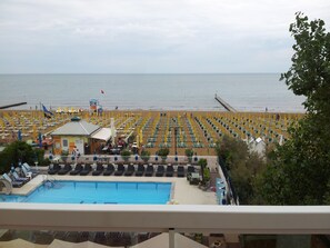 A beachside hotel with a swimming pool, sun loungers, and a view of the sea. - Hotel Panama (Jesolo)