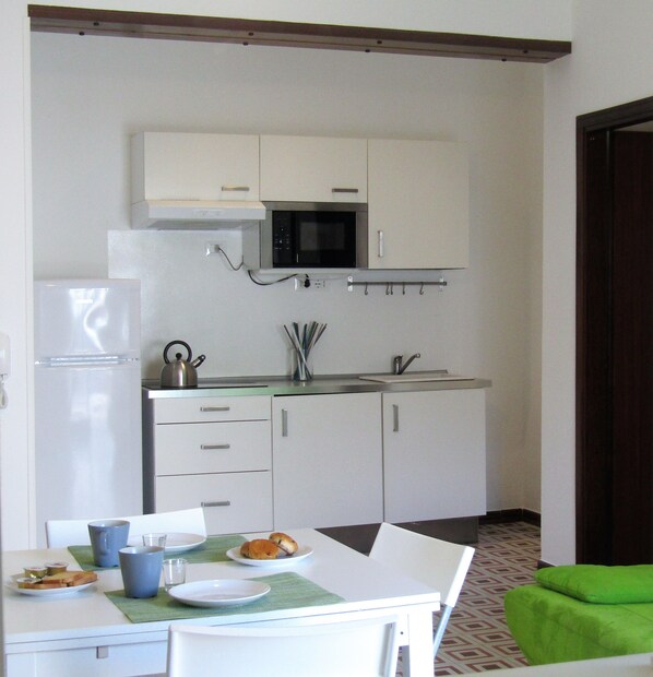 Apartment, 2 Bedrooms | Private kitchen | Fridge, microwave, stovetop, cookware/dishes/utensils