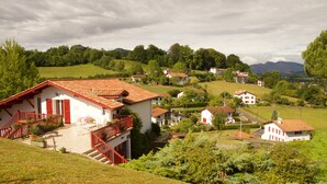 A rural village with traditional houses, a staircase leading to a balcony, and a lush green landscape. - Chambres D'Hôtes Garicoitz (Saint-Jean-Pied-de-Port)