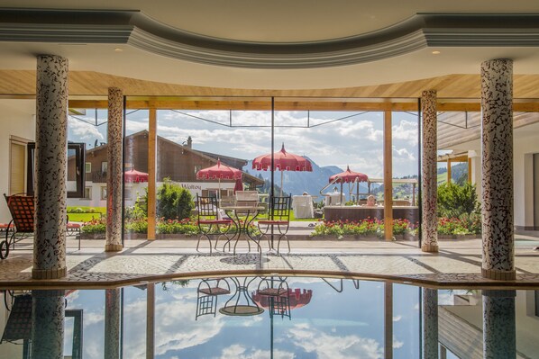 Una piscina techada, sillones reclinables de piscina