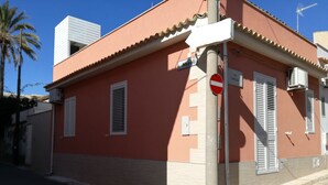 Un bâtiment à la façade rouge, aux volets blancs et portant l’inscription « Napoli ».