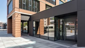 A modern building with large glass doors and windows, a brick facade, and a flat roof. - Elite Apartments Cityview Center (Gdansk)