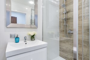 Apartamento, vista para a cidade | Banheiro | Chuveiro, toalhas de banho, papel higiênico 