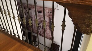 Una escalera con barandales de metal ornamentados y una barandilla de madera.