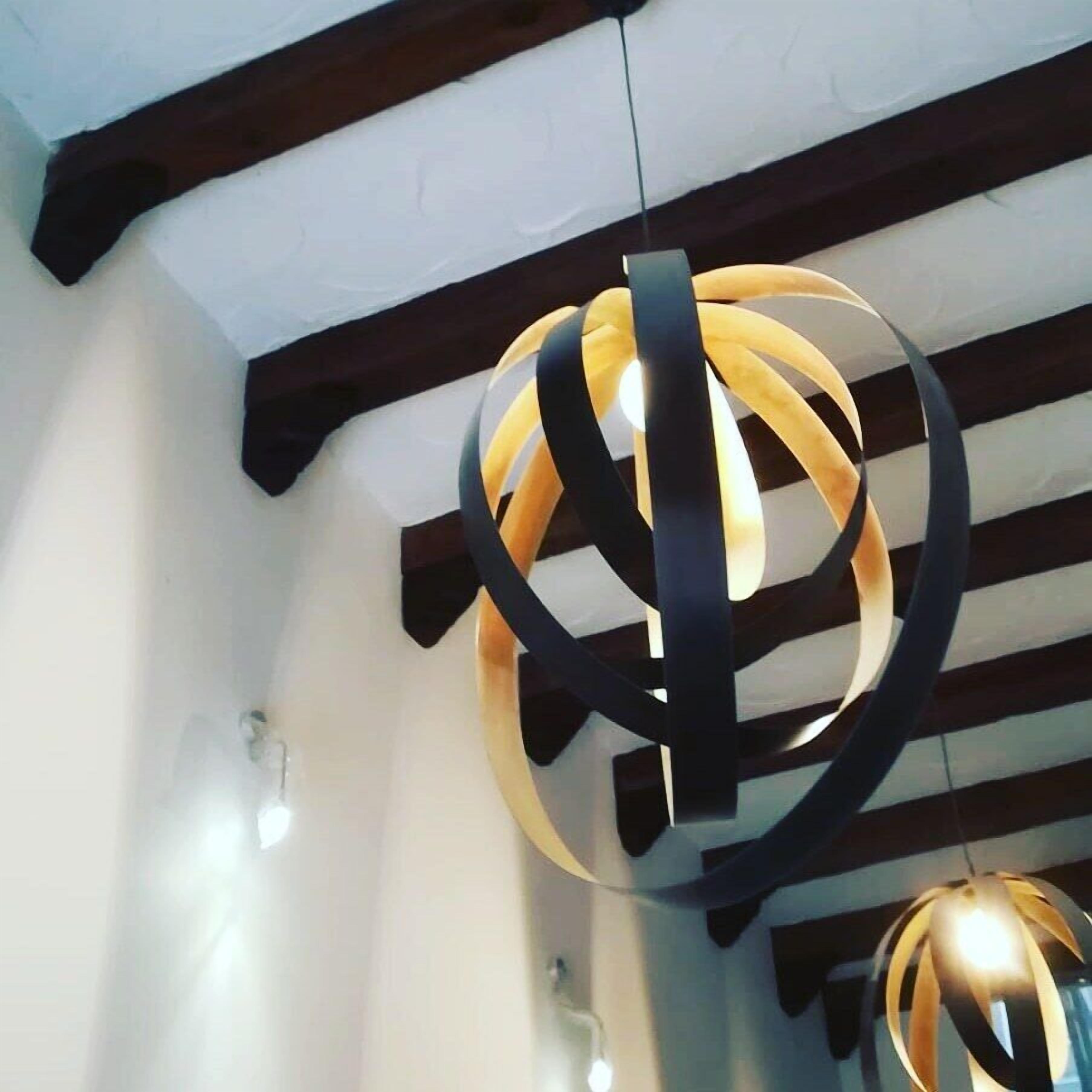 Un candelabro moderno de diseño esférico con detalles en negro y dorado.