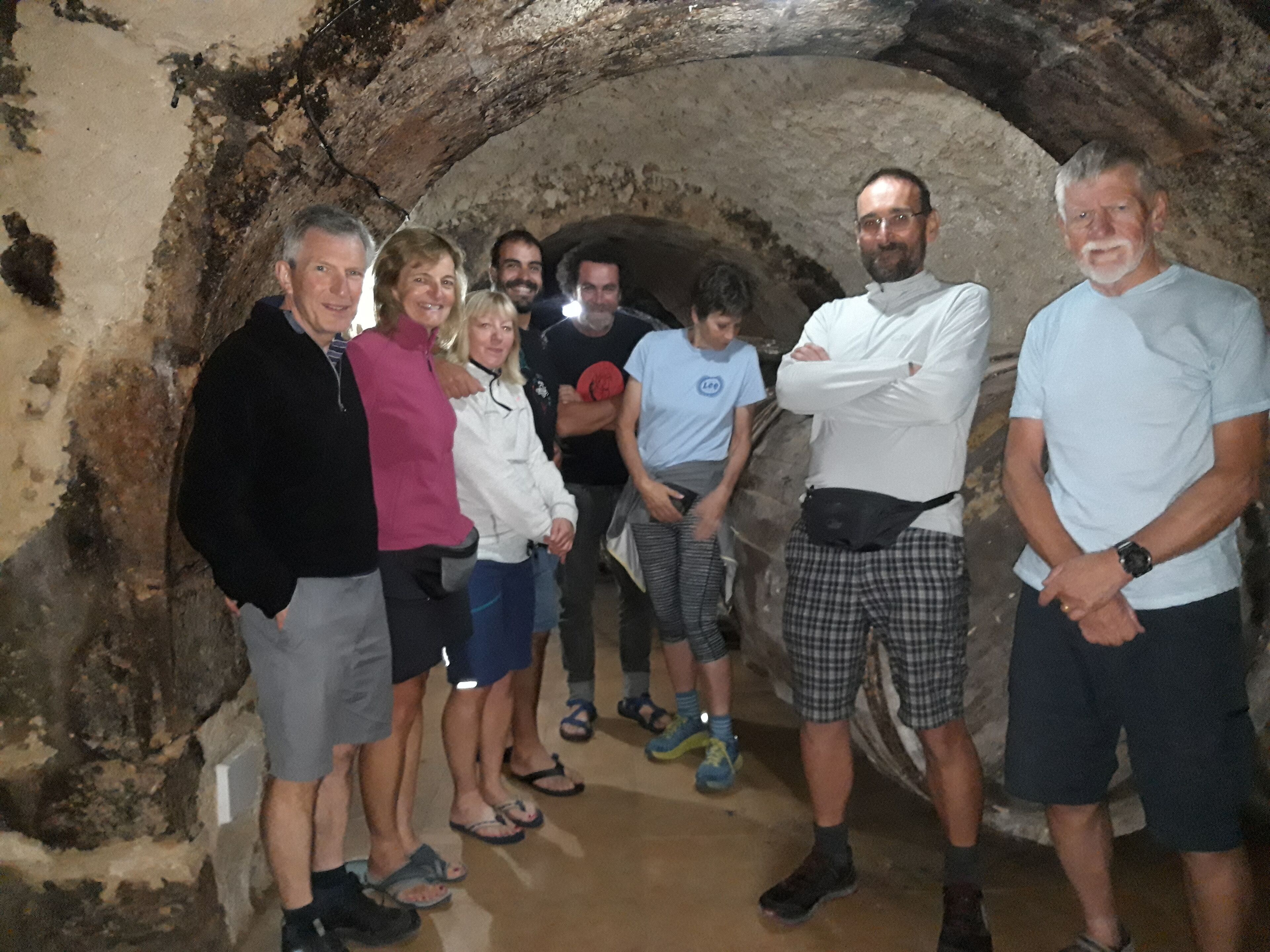 A group of people standing in a stone tunnel.