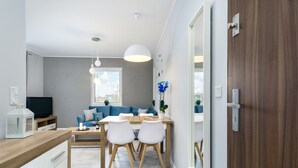 Une cuisine moderne avec un coin repas, un téléviseur et une porte en bois.