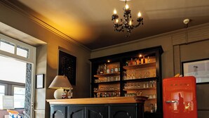 A kitchen with a central island, a chandelier, and a red refrigerator. - Hôtel Restaurant La Maison (Trébeurden)