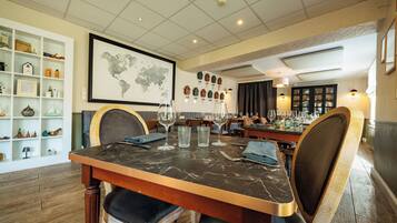 Un comedor con una mesa de mármol, sillas y un mapa mundial en la pared.