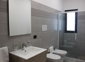 Appartement | Badkamer | Een douche, een haardroger, badjassen, een bidet