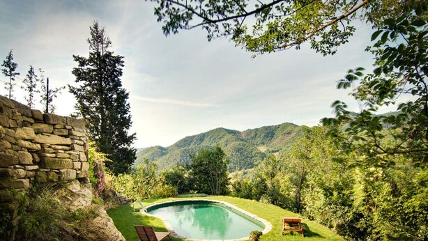 A stone wall, a swimming pool, and a grassy area with two lounge chairs. - Agriturismo Castello della Pieve (Mercatello sul Metauro)