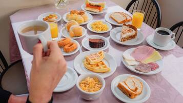 Una mesa de desayuno con diversas comidas y bebidas.