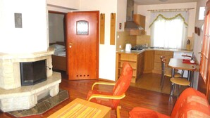 A compact living space with a fireplace, a dining area, and a kitchenette. - Ośrodek Wypoczynkowy Bajka 3 (Lagow)