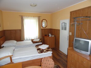 Habitación de hotel con dos camas, televisión, armario y baño.