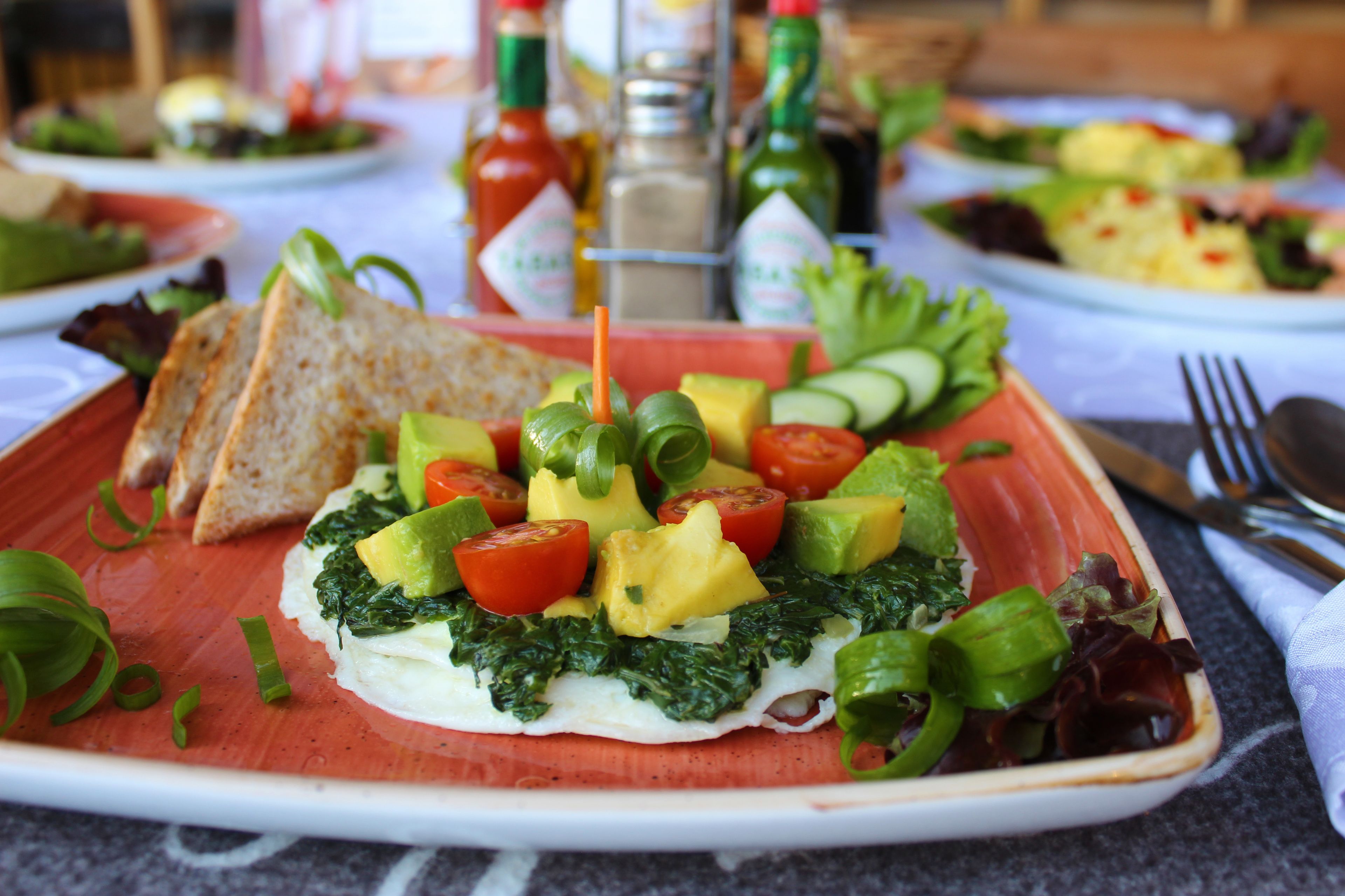 Un plato de comida con varias verduras y un trozo de queso blanco.