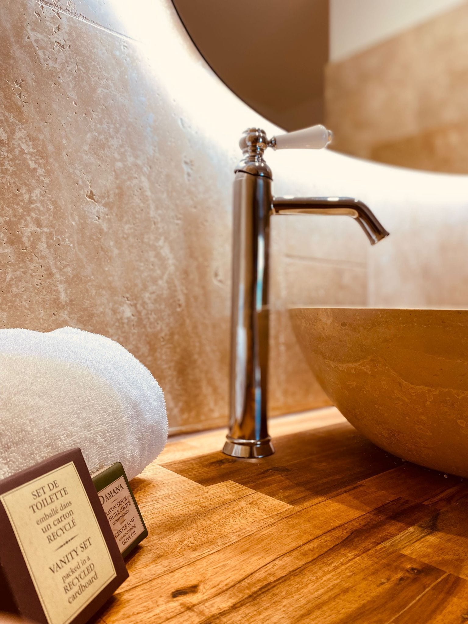 Un baño con tocador de madera, grifo de acero inoxidable y lavabo.
