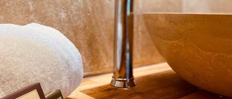Un baño con tocador de madera, grifo de acero inoxidable y lavabo.