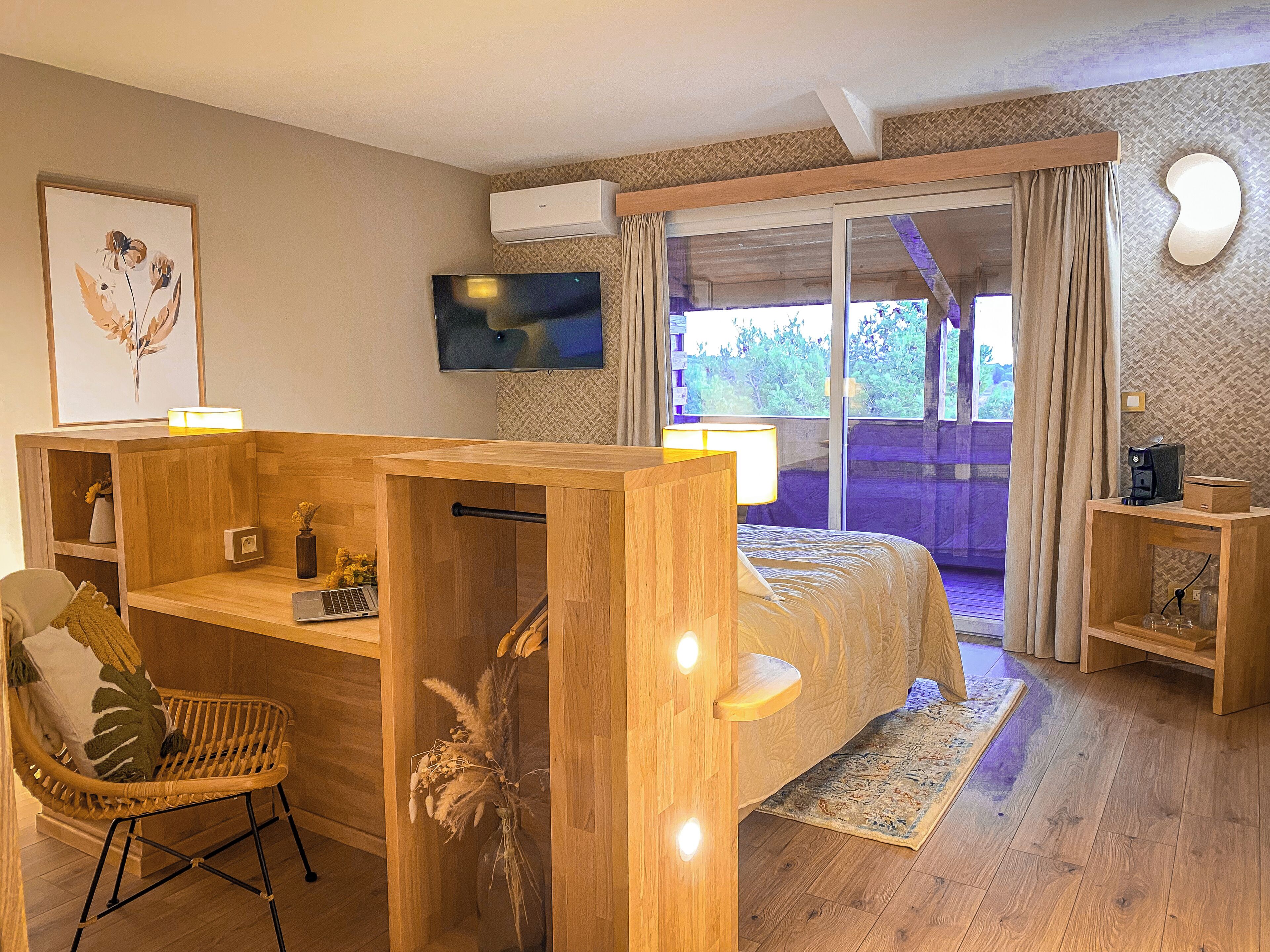 Un dormitorio con cama, escritorio, silla, televisor y ventana con cortinas.