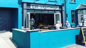 Un edificio azul con un letrero que dice "The Driftwood".