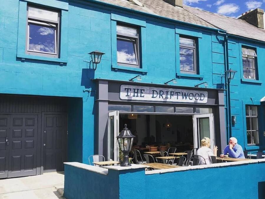 Un edificio azul con un letrero que dice "THE DRIFTWOOD".