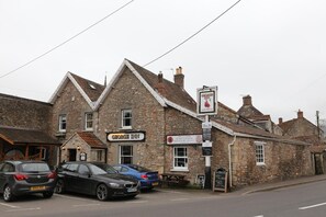 A stone building with a sign for 'George Inn' and a 'B&B' sign.