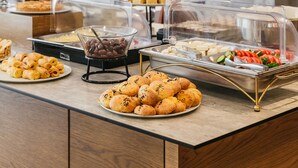 Un buffet proposant une variété de plats, notamment des pâtisseries, des salades et des plats chauds.
