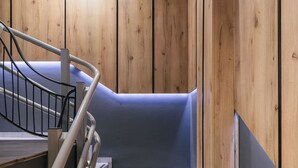 Un escalier en bois avec une rampe métallique menant à un palier.