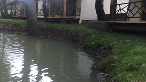 Una passeggiata lungo il fiume con strutture in legno e pareti in pietra.