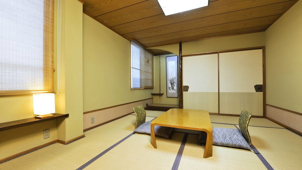 A traditional Japanese room with tatami flooring, a low wooden table, and sliding doors.