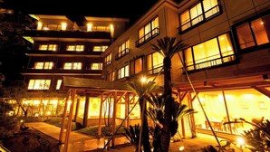 A multi-story hotel with illuminated windows and a covered outdoor area. - Toshimaya Tsukihama-no-yu (Kitaibaraki)