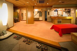 Ein Hotelzimmer mit rotem Teppich, einer Rezeption und einer Treppe.