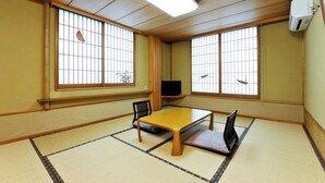 A traditional Japanese room with tatami flooring, a low wooden table, two chairs, and sliding shoji doors. - Toshimaya Tsukihama-no-yu (Kitaibaraki)
