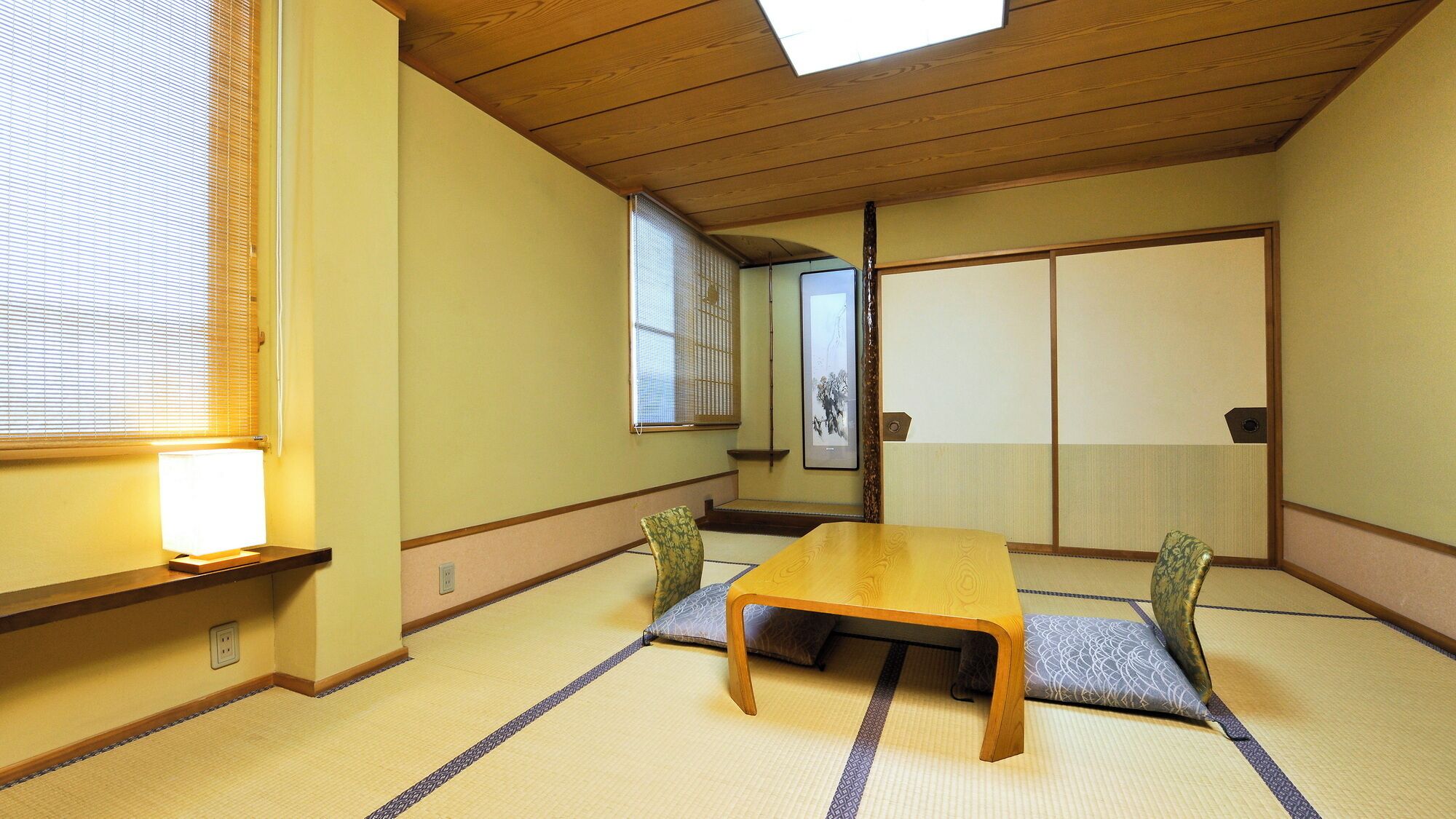 A traditional Japanese room with tatami flooring, a low wooden table, and sliding shoji doors.