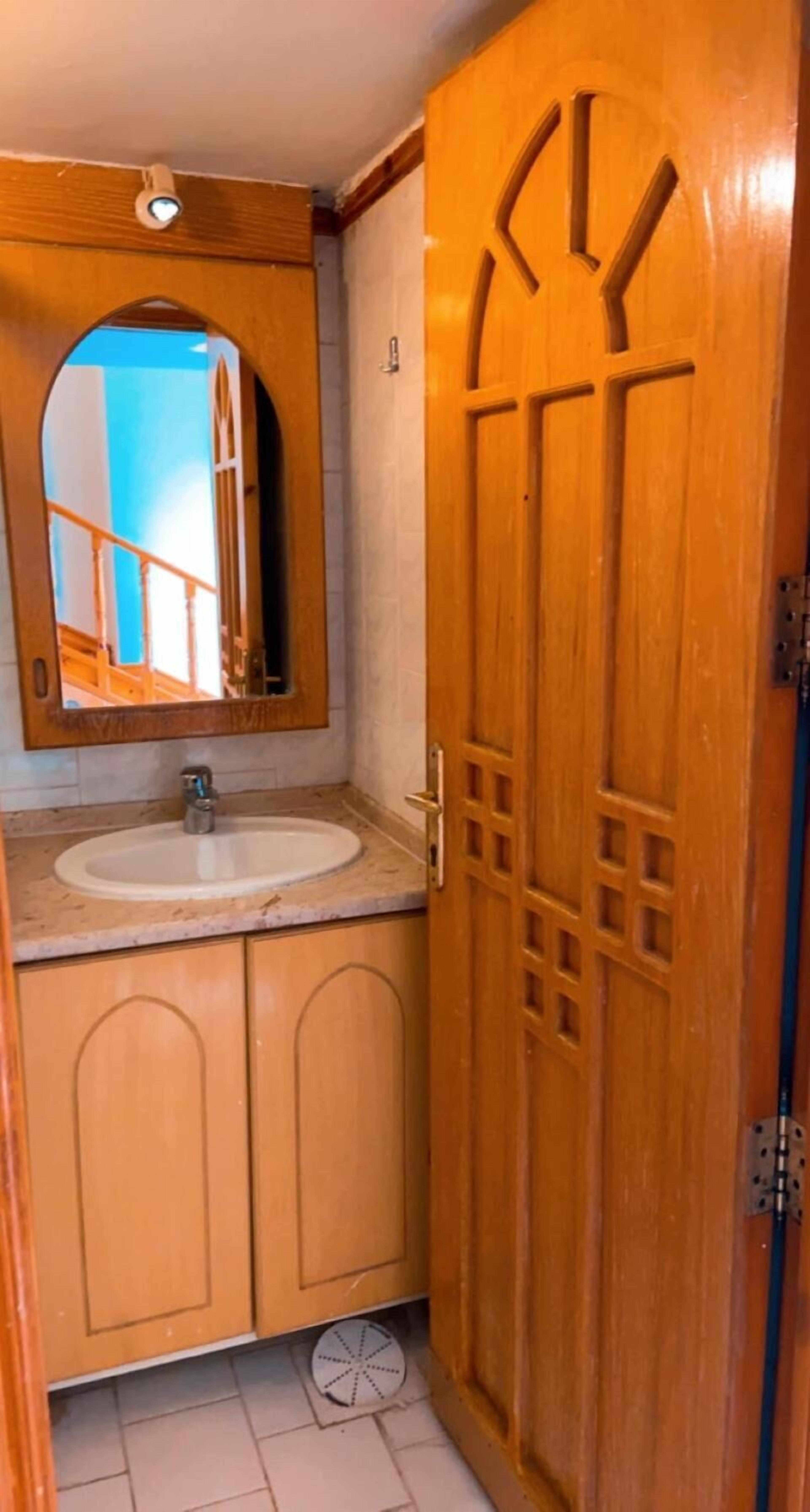 A wooden door with a mirror and a sink.