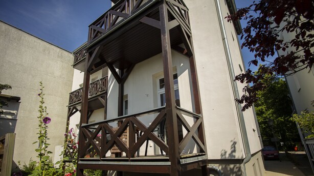 A two-story building with a balcony and a garden. - Ferienwohnungen Eicher Wachtlerstraße (Rostock)
