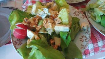 Un plato de ensalada con lechuga, nueces y queso.