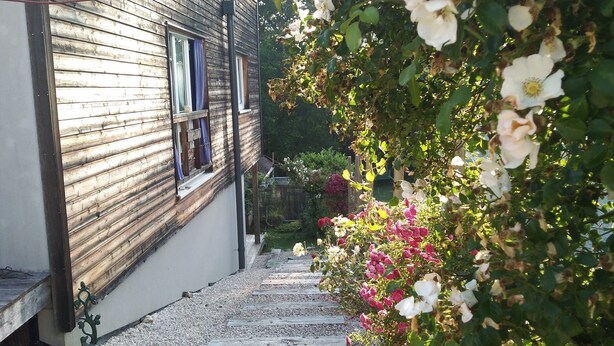 A pathway leading to a wooden house with a window and a door. - Chambres d'hôtes Souffle Nature  (Montenois)