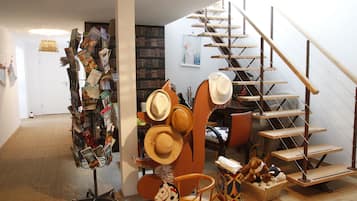 Experience a space that showcases eclectic style and personal touches, featuring a bookshelf, hat display, and unique decorative items.