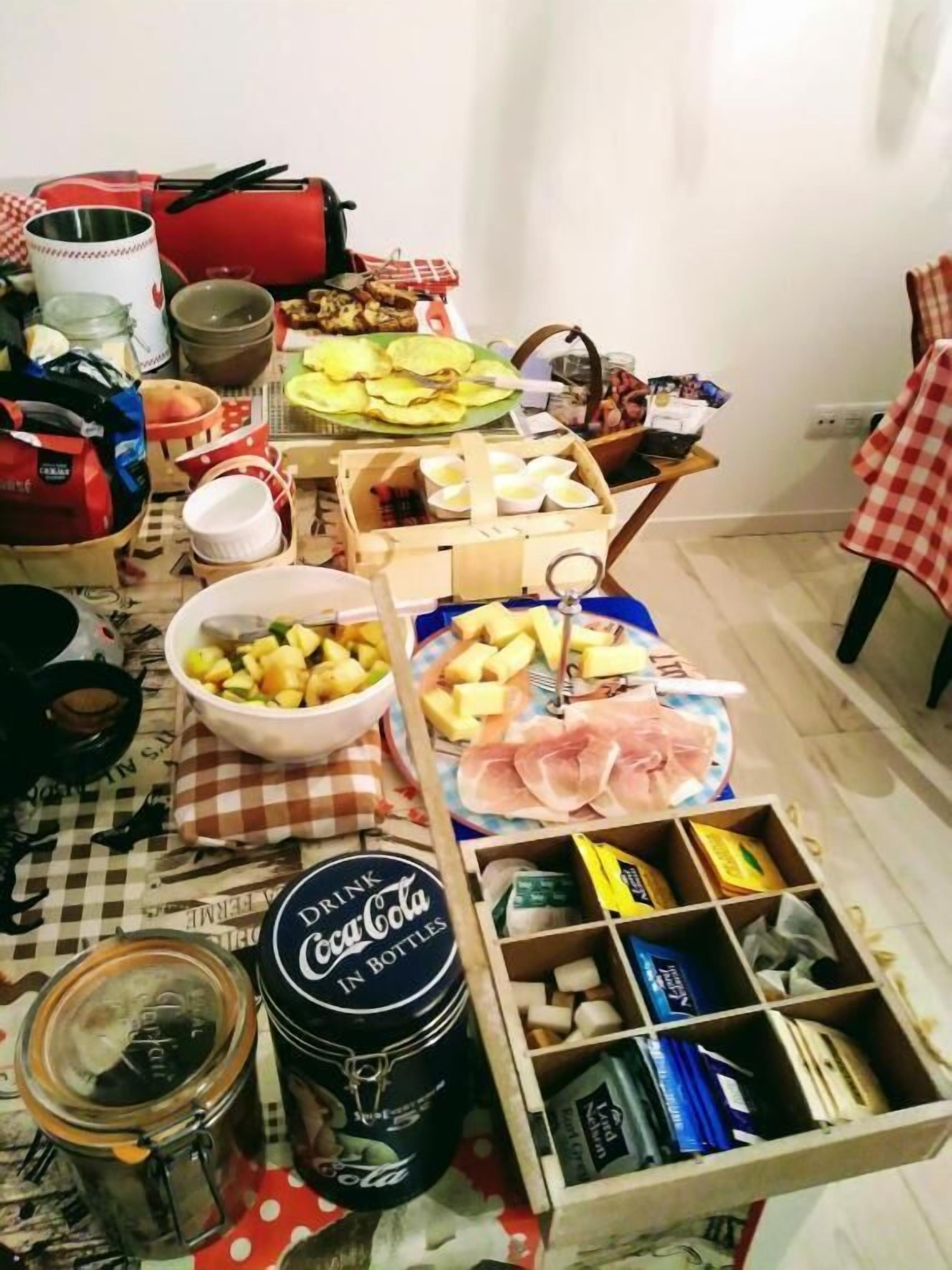 A table with various food items, a Coca-Cola bottle, and a red bag.