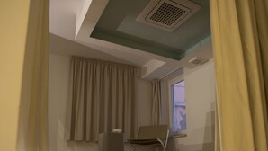 A modern bathroom with a glass-enclosed bathtub, beige walls, and a window with curtains. - B&B La Gaetana (Gaeta)