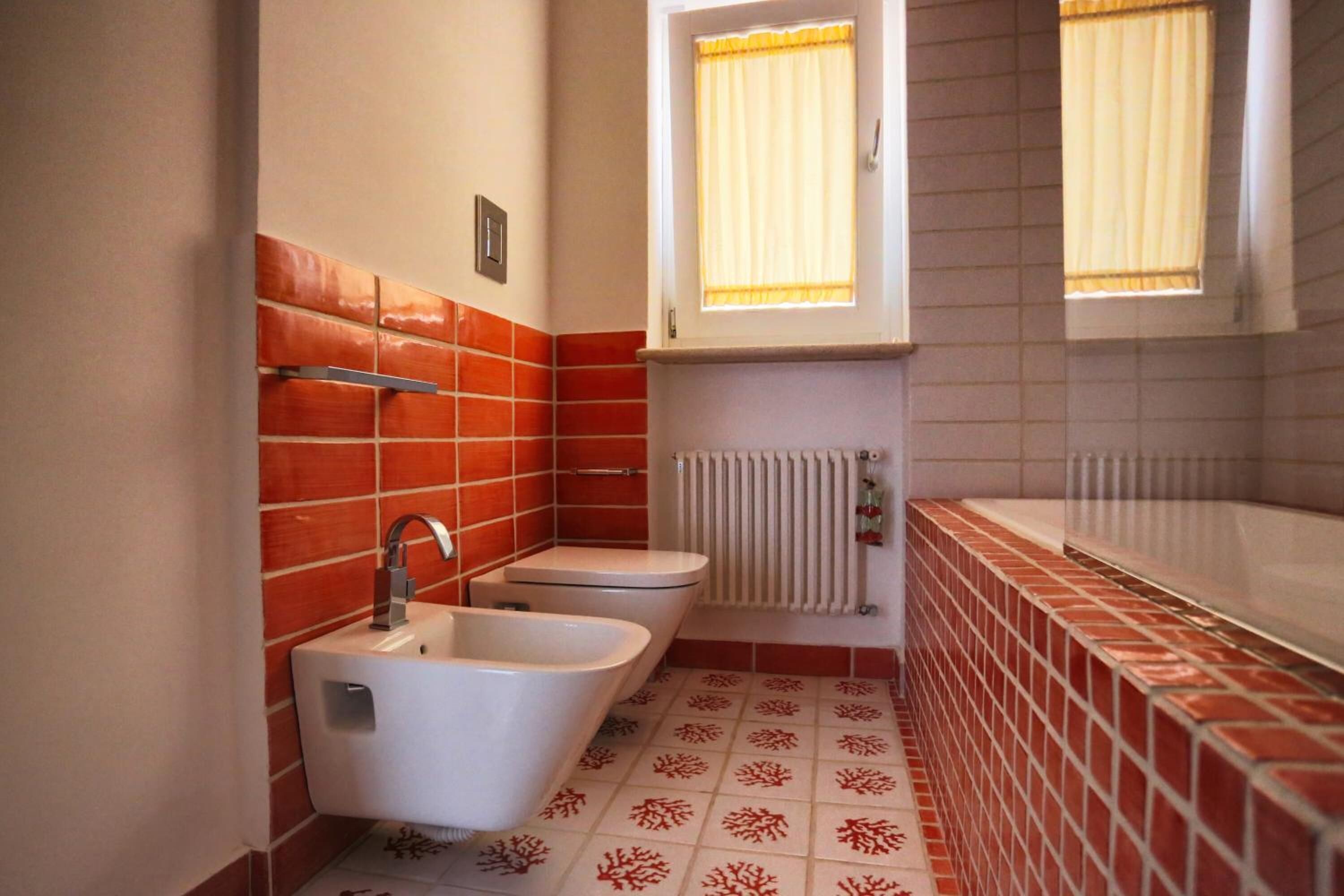 Un bagno compatto con una vasca da bagno bianca, un lavandino e un water.