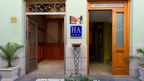 A hotel entrance with a sign reading "Edificio Capitolina" and a blue sign with "HA" and suns. - Aparthotel Capitolina (Merida)