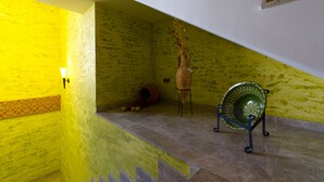 A staircase with yellow walls and a green glass bowl on a stand. - Aparthotel Capitolina (Merida)