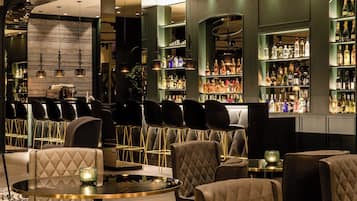 A bar area with seating and shelves of liquor bottles.