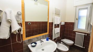 A bathroom with a sink, toilet, and hairdryer.
