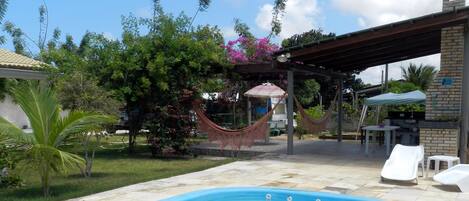 Una piscina al aire libre, sillones reclinables de piscina