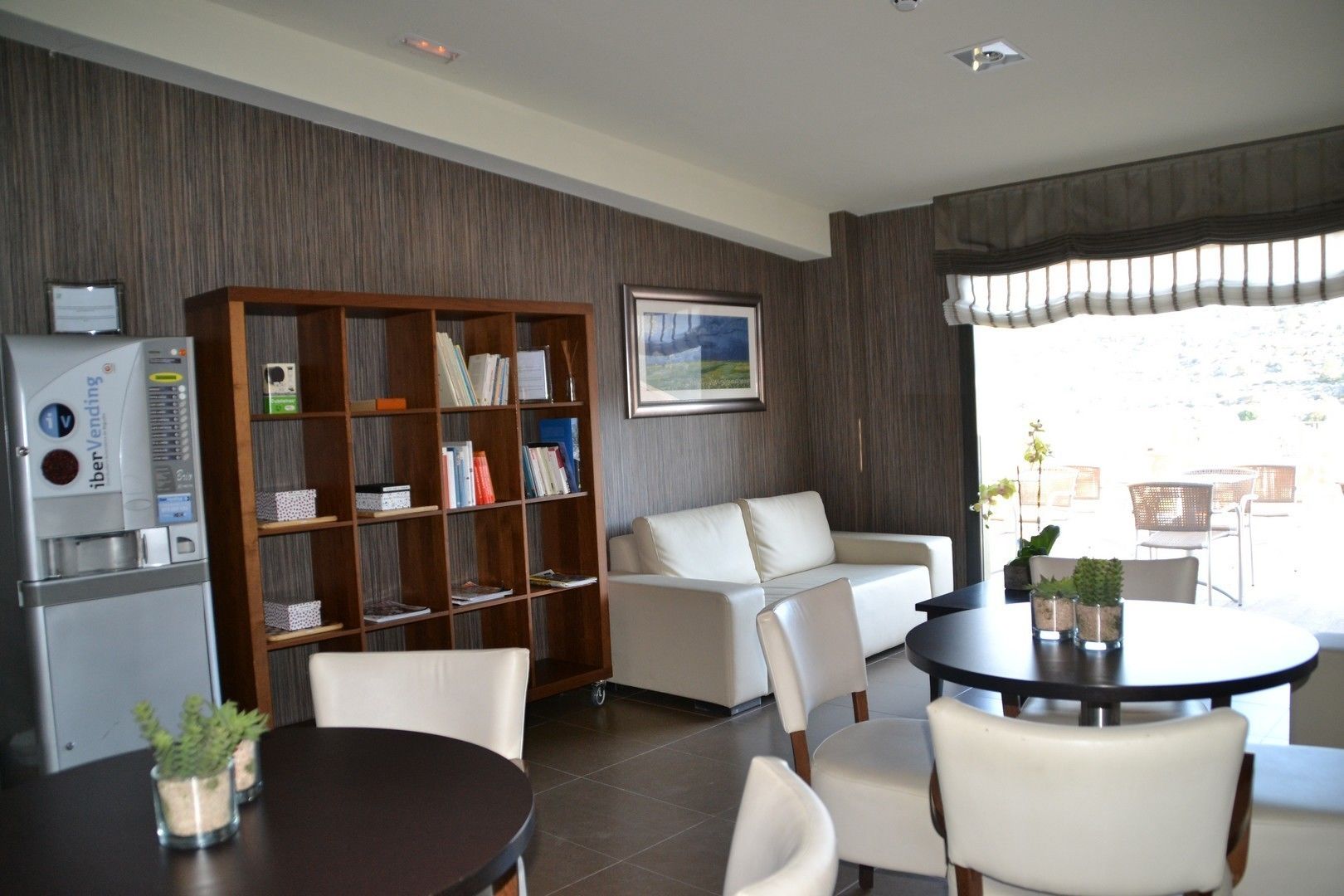 A modern living room with a sofa, a coffee table, and a bookshelf.