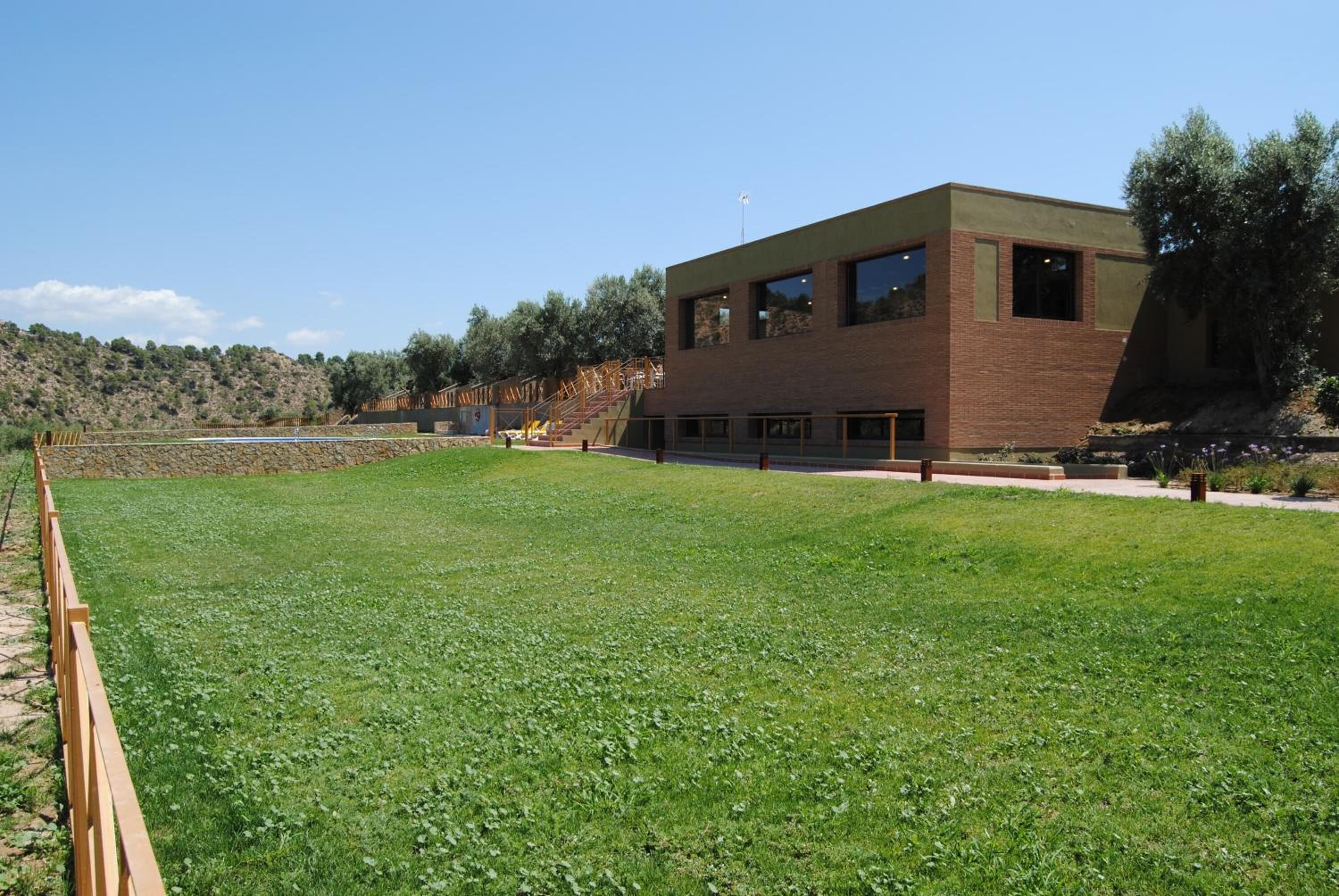 Un edificio moderno con tejado plano, ventanas amplias y fachada de ladrillo.