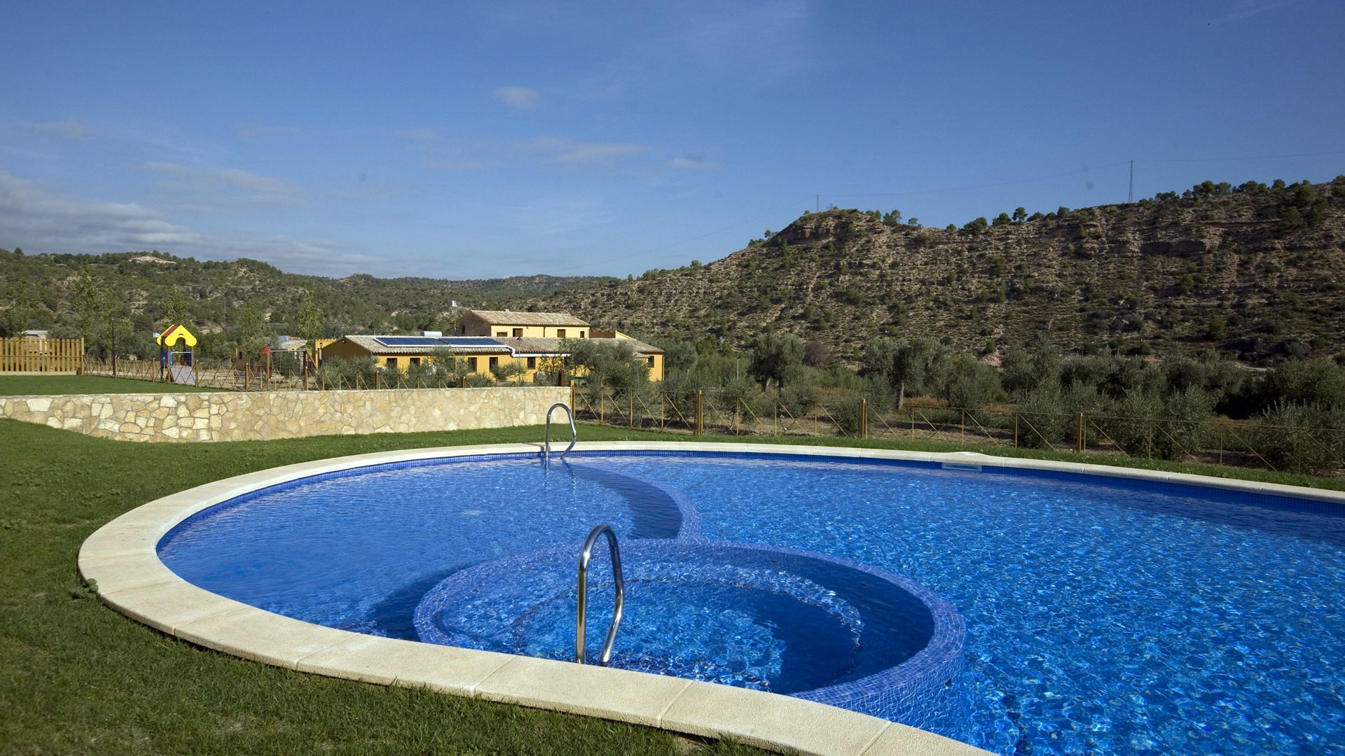 Een buitenzwembad, parasols voor strand/zwembad